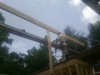 Carpenter setting a ridge beam over a new addition frame — Ice Dam Removal by Roofing Brothers in Middle Haddam