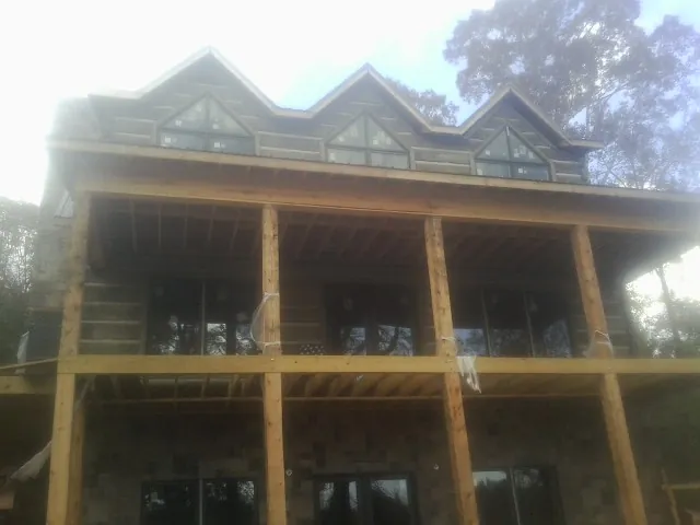 Dormers and porch framing on a large log home under construction — Roof Coating work by our crew in Middle Haddam