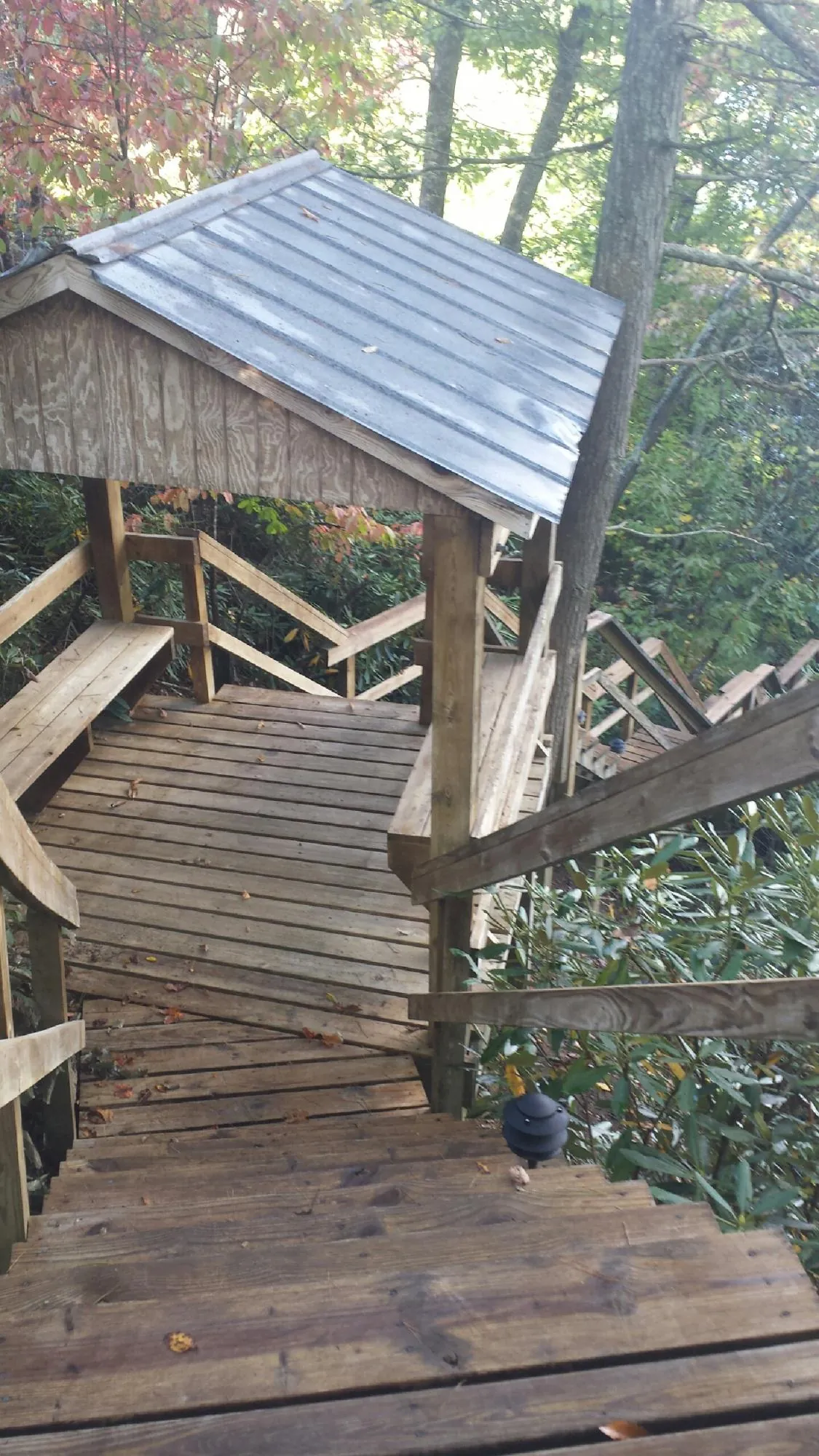 Metal roofed shelter over wooden steps on a wooded walkway — Skylight Repair & Installation work by our crew in Middle Haddam